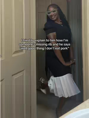A woman in a black dress with a white skirt over it is standing in a doorway. She is wearing glasses and smiling. Text overlays the image.