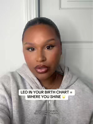 A selfie-style shot features a woman in a gray hoodie. The background is a plain white wall. Text overlays highlight information about Leo in a birth chart.