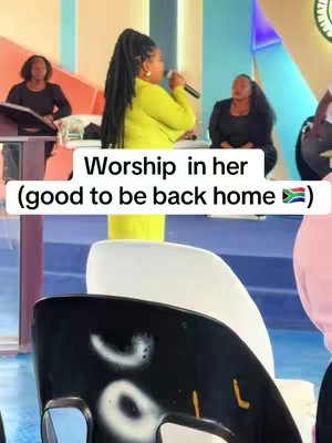 A woman in a lime green blazer is singing into a microphone in a church setting. Two other women are in the background, one at a podium and the other seated. The composition includes chairs and parts of the church's architecture with text overlaid.