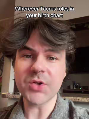 A medium shot shows a person with dark wavy hair facing the camera. The person has fair skin, a nose ring, and is speaking. Above them, clear text states: “Wherever Taurus rules in your birth chart.” The background is slightly visible, suggesting an indoor setting.