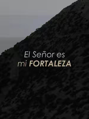 The image is dark, featuring a grainy, textured background that suggests a rock face or mountainous terrain. The upper right portion is darker. Overlaid on this is white text, positioned centrally, that reads, "El Señor es mi FORTALEZA". The words are stacked, with "FORTALEZA" in a larger, bold font emphasizing the core message.
