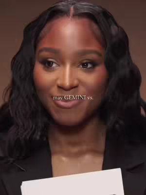 A woman with dark wavy hair looks towards the left, smiling slightly. The text overlay 'may GEMINI vs.'appears at the bottom.