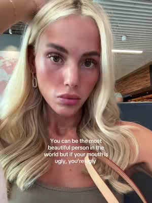 A selfie-style video shows a fair-skinned woman with long, wavy blonde hair. She's looking directly at the camera with a serious expression. The text overlay is white and centered at the bottom of the frame with each line. The background appears to be a brightly lit interior.