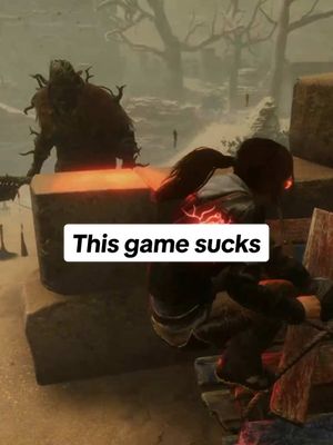The image shows a scene from the game Dead by Daylight, featuring a dark, menacing figure in the background and a survivor figure being attacked on a stone structure in the foreground. The scene is set with a moody, foggy background, with dry trees. A text overlay says 'This game sucks'.