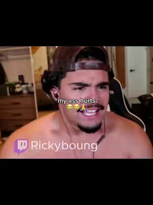 A selfie-style shot of a man, with a medium-brown hair and wearing a brown baseball cap. The man is shirtless and looks slightly disheveled, with a somewhat pained expression and a slight smile. The background suggests an interior setting, likely a room, although the details are blurred. Text overlay includes an expression of discomfort. A logo reading  'Rickyboung' is at the bottom.