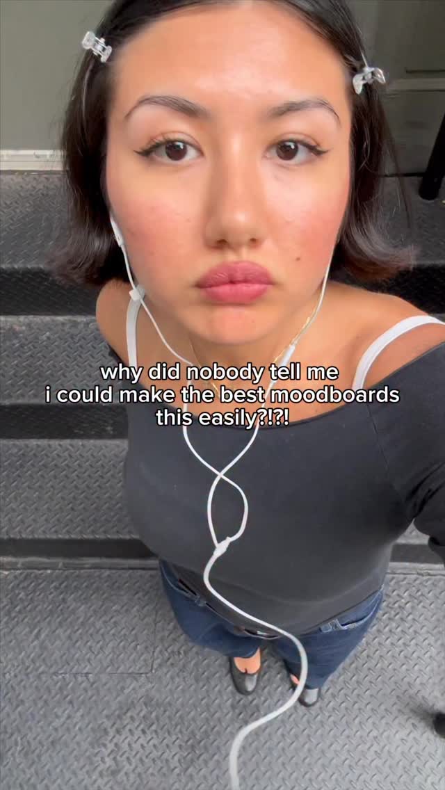 A selfie-style shot, taken from a high angle, features a young woman with dark hair and fair skin. She's facing the camera directly, with text overlayed at the lower center. The woman is wearing headphones and a black top. She has a touch of blush on her cheeks and her lips are a deep pink. The background consists of grey, metal steps. The overall mood is casual and focused, likely a commentary on the content.