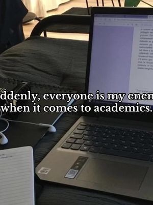A laptop sits open on a desk or bed, displaying text on the screen with a notebook and headphones nearby. Text overlayed on the image reads a statement about academics.