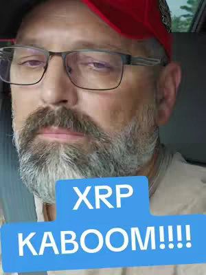 The cover image is a selfie of a middle-aged man in a car. He wears glasses and a red baseball cap. A light blue speech bubble with white text that says "XRP  KABOOM!!!!" covers part of the image.