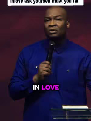 A man in a blue shirt speaks, holding a microphone. Text overlays read 'IN LOVE' in white with a pink highlight, placed mid-image.