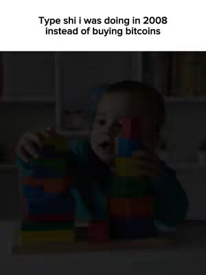 A young child is seen in a dimly lit room, focused on stacking colorful building blocks. The child is wearing a blue shirt, with two towers of blocks in the background. The text overlay at the top reads 'Type shi i was doing in 2008 instead of buying bitcoins'.
