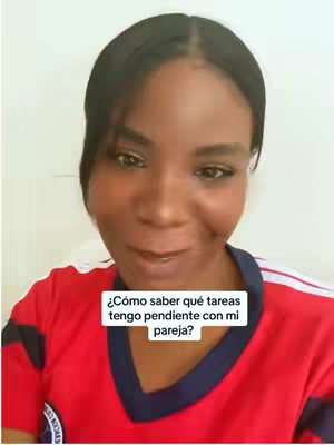 A woman with dark hair and a red and blue shirt is the main subject of the image. She is centered in the frame, looking towards the viewer.  A rectangular text box is overlaid near the bottom center with white characters.