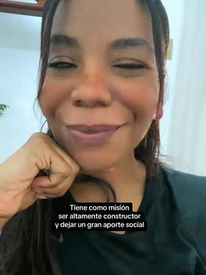 A medium shot of a woman looking towards the camera with a slight smile, with one hand near her chin. The text overlayed on the bottom of the image.