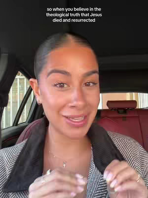 A woman is speaking from inside a car, with text overlay in the top part of the video. The woman presents her upper body, wearing a blazer, with the background of the car and a window showing a blurred street scene.