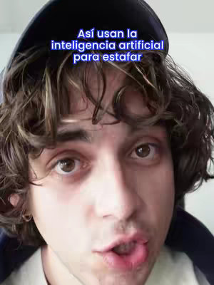 A close-up shot of a young man with curly brown hair, wearing a dark baseball cap. The image focuses on his face, with text overlaid at the top. The man has fair skin, dark eyes, and is looking directly at the camera with his mouth slightly open. The background is blurred and indistinct, suggesting a close proximity shot.