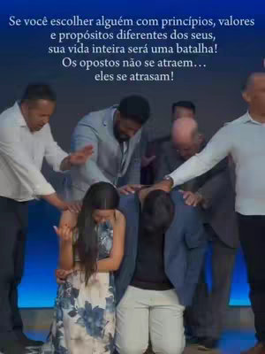 The image shows a group of people gathered closely together, with several individuals placing their hands atop the heads of two people who appear to be kneeling. Text is overlaid at the top, written in Portuguese.