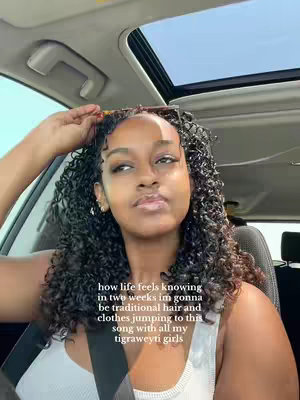 A selfie taken from inside a car, the creator's face is the main focus, with curly hair and a contemplative expression. Text overlayed on the image describes the creator's feelings and plans for an upcoming event.