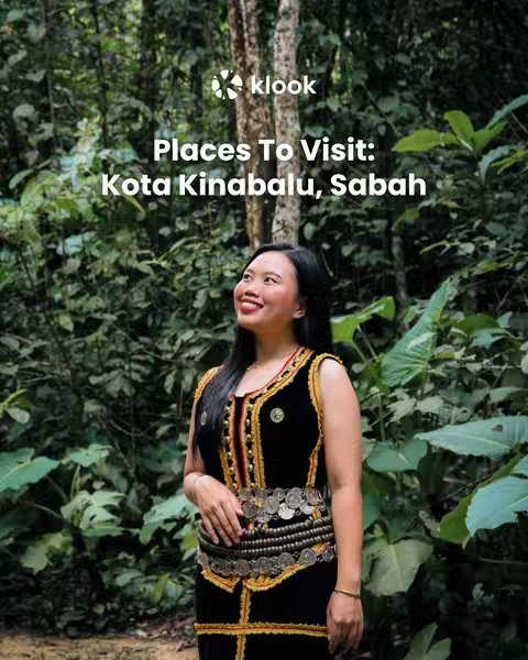 A woman dressed in local attire stands in a lush green forest setting. She is smiling, and the image has a natural, vibrant feel.