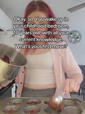 A woman with pink hair is pouring a mixture from a silver bowl into muffin tins. Text overlayed on the image poses a question about time travel and childhood.