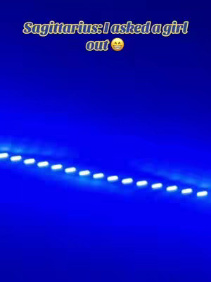 The image is a vertical shot with a deep blue background. Along the bottom is a glowing streak of white lights in a dashed sequence, sloping upwards slightly. At the top, stylized, yellow text says "Sagittarius: I asked a girl out 😅". The text has a slight shadow.