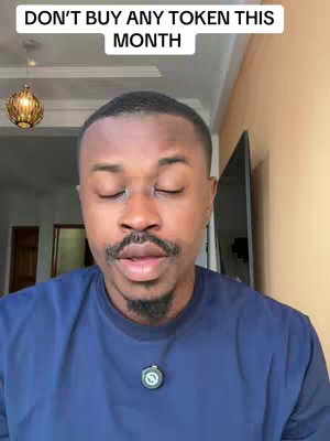 A man with short black hair and a mustache is giving a video-recorded message. He wears a navy blue shirt, and the overhead lighting suggests a room inside a home or office. In the background, there's a hint of a window, door and a television.