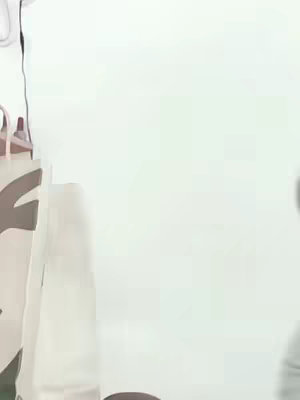 The image is a blurred, abstract composition with a predominantly white background. A portion of a person is visible on the left side, showcasing a partial view of their clothing, which appears to be a light color, possibly white or cream. The right side of the image is mostly an empty white space.