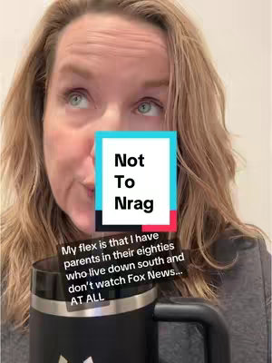 A woman with light brown hair looks up with a slight smile, with a text overlay that reads "Not To Nrag," and a caption below. She is holding a black mug with a silver rim close to the camera. The background is a white or light-colored wall.