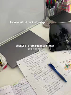 A top-down shot of a desk with study materials. There's a laptop, a tablet, and a notebook with handwritten notes. A blue pen lies on top of the notes. Text overlays the image, describing a personal struggle and determination.