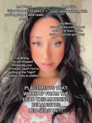 A selfie-style image with a woman in the center, dark hair framing her face. She is looking at the camera with minimal makeup, and her skin is fair. Various text overlays are placed around her head, describing astrological aspects related to Leo season. The background is blurred, focusing attention on her face.