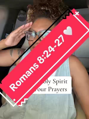 A woman wearing glasses and a denim top is raising her right hand to her forehead in a saluting gesture. Overlaid across her is a red banner with white text and a white heart, featuring the text 'Romans 8:24-27'. Below this is a white box stating, 'Holy Spirit for our Prayers'. The background includes a car's interior.