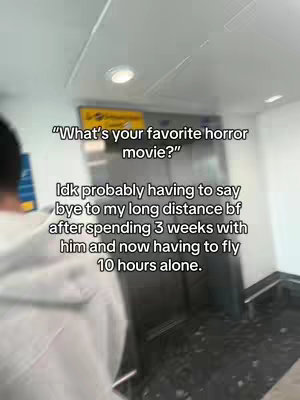 A person is seen from the back, standing in an airport or similar indoor space. Text overlays frame the scene, with a question in quotation marks followed by a personal lament about saying goodbye to a long-distance boyfriend. The background is out of focus.