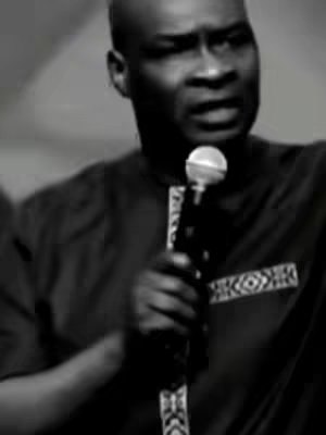 The cover image is a black and white photo of a man with a shaved head, wearing a dark shirt, holding a microphone. The man appears to be giving a speech. The background is out of focus, which puts emphasis on the speaker. The microphone is held up near the man's mouth.