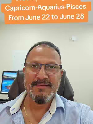 A man with a beard and glasses is seated in a chair and looks directly at the camera. Text overlayed on the image indicates a weekly astrology reading, featuring highlighted zodiac signs. The background is a blurred interior.
