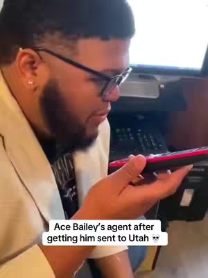 A man in a white jacket and glasses holds a phone up to his face, appearing to be on a call. Text overlay states 'Ace Bailey's agent after getting him sent to Utah'.