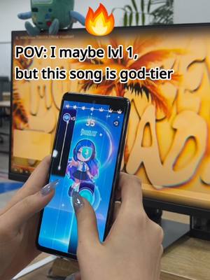 A person holding a smartphone playing a music game. The screen displays the game interface with colorful graphics and moving tiles. Text overlays appear on the screen, and the background features a tropical-themed design.