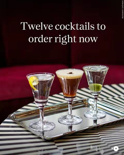 A stylish cover image showcasing three different cocktails on a silver tray. The cocktails are in elegant stemmed glasses, each with a unique presentation. The background is a blurred burgundy color, suggesting a sophisticated bar setting.