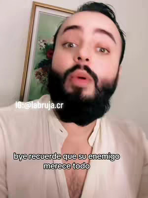 A man with a beard is looking at the camera and speaking. There is text overlayed on the bottom of the frame.