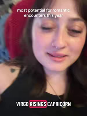A selfie-style video cover showing a young woman with dark hair smiling softly, slightly turned to the side. Above her are overlayed white text captions and below is a red banner with white text. The background is blurred with reddish hues.