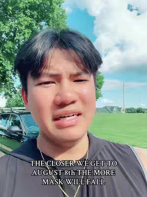 A young man with short, dark hair stands in front of a bright blue sky with fluffy white clouds and a grassy field. He is wearing a black top and a gold necklace. Text overlayed on the image reads a message about an upcoming date.