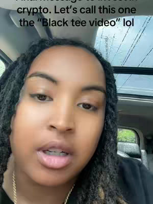 A close-up shot of a woman with long, dark dreadlocks is seen from the chest up. She's looking slightly to the side with a direct gaze at the camera. She has fair skin with dark eyebrows and eyeliner.