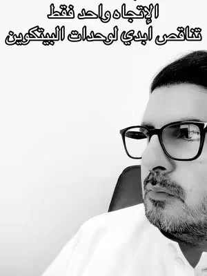 Monochrome image of a man seated near a white wall, focused on his face. The man is wearing black-rimmed glasses, and he has a well-groomed beard and mustache. The lighting suggests a simple backdrop, and text in Arabic is overlaid.