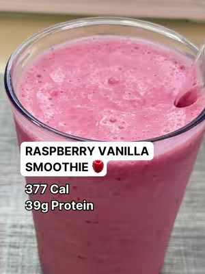 A close-up shot of a glass filled with a vibrant pink smoothie. The glass is clear, and the smoothie appears to be a smooth, blended mixture. A white rectangle with black text overlays the drink. The colors are dominated by pink and white, with a dark gray background.