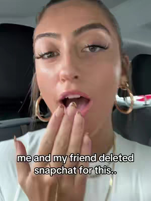 A close-up shot featuring a woman with fair skin, long eyelashes, and styled eyebrows. She's wearing large hoop earrings and has her mouth open, as if in surprise or speech, with a hand raised towards her mouth. Text appears at the bottom of the image.