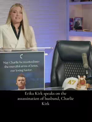 The cover image shows a woman speaking in front of a large sign and a blurred background. The woman is blonde and wearing a white blazer. The sign in front of her includes text and an image. There is a microphone in the background and a blurred image of what looks like an office setting around her.