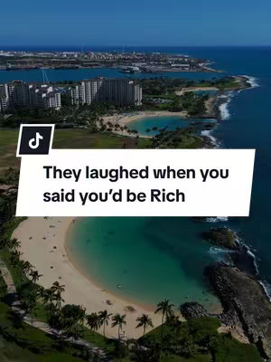 An aerial view of a tropical landscape, featuring a bright blue ocean and a sandy beach with palm trees. In the middle ground, there's a lagoon with clear turquoise water and some buildings. The layout is framed by blue water, greenery, and a clear sky and the main focus is on the beach and the hook text.