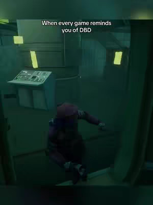 The image shows a character in a video game in a dark, industrial setting. The character, viewed from behind, is wearing a red-and-purple outfit and is crouched. The environment is primarily shades of green and gray, with angular metal structures and dim lighting.