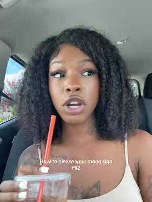 A woman sits in a car holding a clear cup with a straw. She is looking toward the camera, with an open mouth. The text overlay says, "How to please your moon sign Pt2".