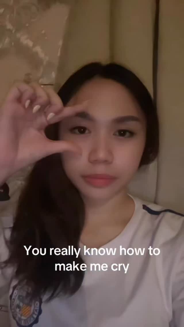 A close-up of a woman facing the camera, making a gesture with her hand while text overlays the bottom half of the screen.