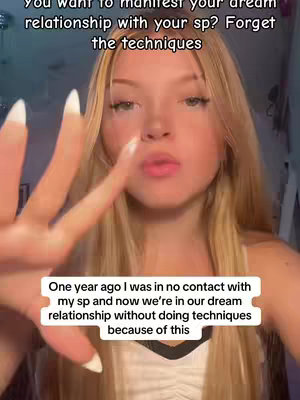 A young woman with long blonde hair and a light complexion is centered in the frame. She is facing the camera, with a hand held up near her face displaying the peace sign. Her lips are lightly glossed, and her eyes have subtle makeup. Two separate text boxes overlay the image, one above her head and one at the bottom. The background is blurred, suggesting a room setting indoors.