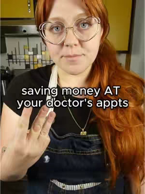 A woman with red hair and heart-shaped glasses stands in front of a blurry background. She wears a black top, a denim apron, and a silver necklace. She's making a hand gesture with her fingers. Text overlayed on the image reads 'saving money AT your doctor's appts'.