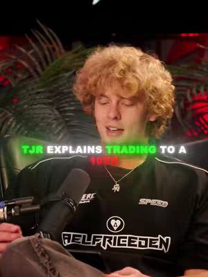 The cover image shows a young man with curly blond hair sitting in a chair and holding a microphone. The man is smiling and appears to be in a studio setting, as suggested by the red lighting and dark background. Text overlaid on the image reads "TJR EXPLAINS TRADING TO A 10YO".